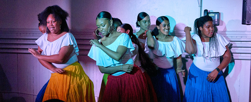 a group of women perform Afro Cuban dance